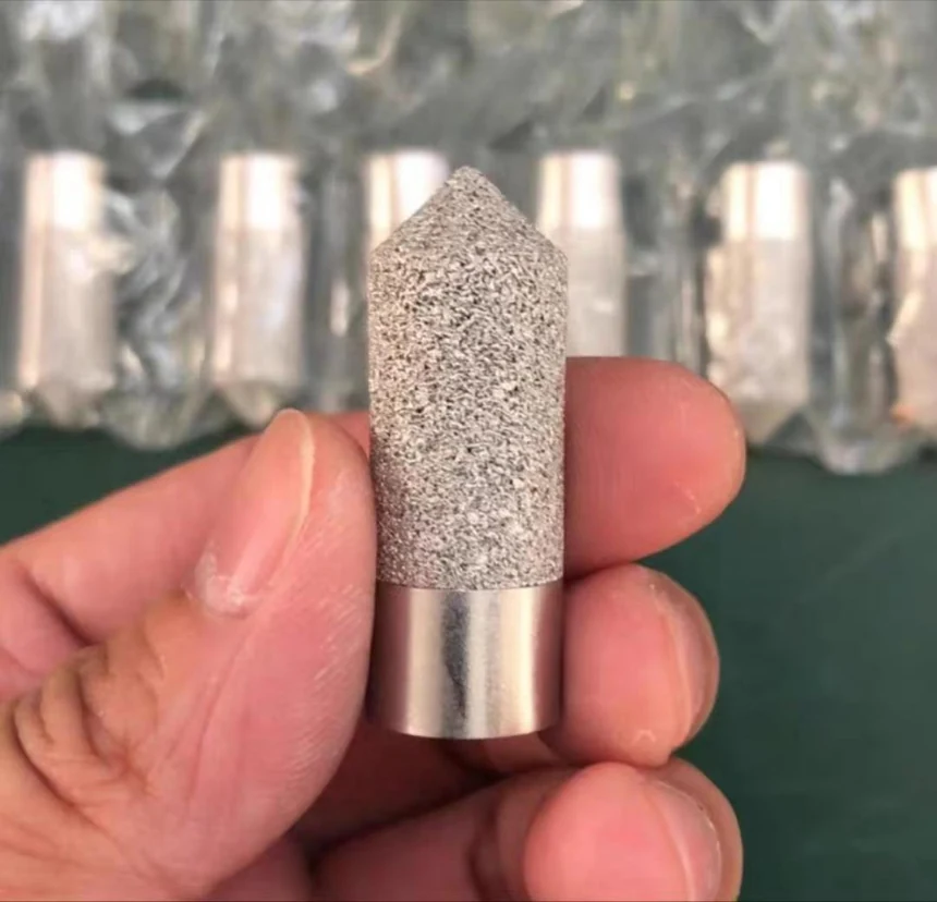 Sintered porous metal filter element held in the hand